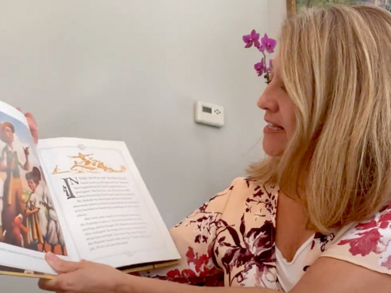 adult woman viewing page of a children's picture book